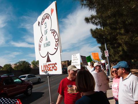 The sign says: Obama, Reid, Pelosi, 3 of a kind, loosers