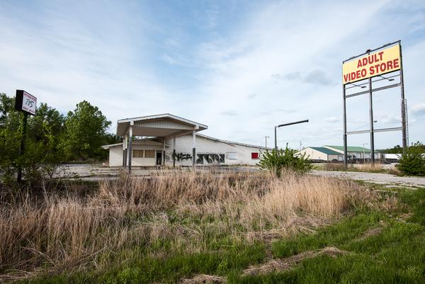 An abandoned, boarded-up porn store